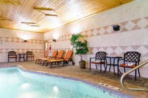 a swimming pool with chairs and a table and a tablektop at Comfort Suites Salina South in Salina