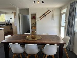 a dining room table with white chairs around it at Trout Retreat - Turangi Tongariro in Turangi