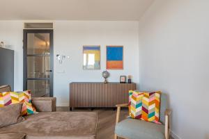 a living room with a couch and a chair at Uithaven 1B Kamperland, view of harbour in Kamperland