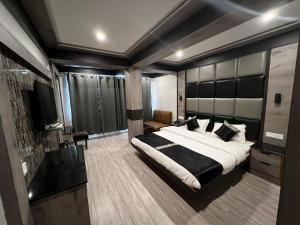 a bedroom with a large bed and a television at Hotel Victory since 1979 in Shimla
