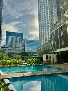 a swimming pool in a city with tall buildings at Pool view Studio with WiFi & Netflix , Avida Riala in Cebu City