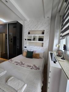 a small bedroom with a bed and a white wall at Arizona in Novi Sad