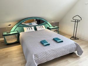 a bedroom with a large bed with two pillows on it at Villa Isaac - Piscine naturelle - Proche Boulerie Jump - 8p in Le Mans