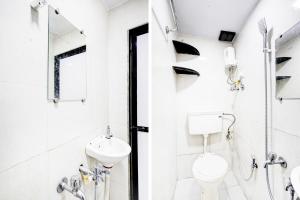 a white bathroom with a toilet and a sink at Super Hotel O BKC Santacruz East in Mumbai