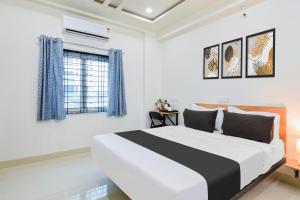 a white bedroom with a large bed and a window at Super Townhouse Kokapet Formerly Aarian Tej Nilayam in Hyderabad