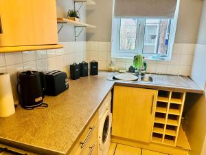 a kitchen with a sink and a counter top at Chic 2BR escape near Luton Airport&Train Stn, Whipsnade zoo, Contractors in Luton +23 photos