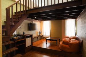 a living room with a staircase and a couch at Thanicha Resort Amphawa in Amphawa