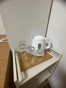 a tea kettle and glasses on a shelf in a refrigerator at 福苑李 in Osaka