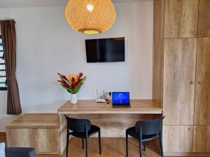 a room with a desk with a laptop and chairs at Papeari sea side 1 Logement neuf en bord de mer in Otutara