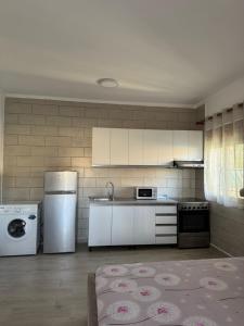 a kitchen with white appliances in a room at Davide's guesthouse in Vlorë +15 photos