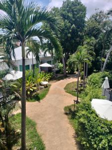 a path leading to a resort with palm trees at 4U Resort Samui in Lamai