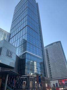 wysoki budynek ze szklanymi oknami w mieście w obiekcie Xihe Light Luxury Self-service Apartment w mieście Chengdu