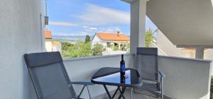 a bottle of wine sitting on a table on a balcony at Bella Nina Apartments in Šilo