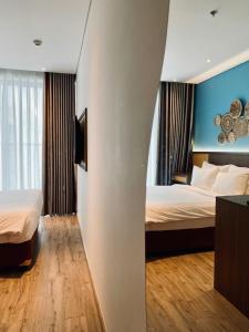 a hotel room with two beds and blue walls at Kira Kira 's Apartment, Apec Mandala Phu Yen Condotel in Tuy Hoa +171 photos