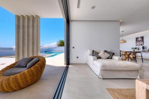 a living room with a couch and a chair at White House - Fire pit and Private pool By Lanzarote Vacation Homes in Puerto Calero