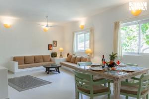una sala de estar con una mesa y un sofá en StayVista at Suite De Regal, en Mandrem