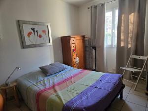 a bedroom with a bed and a dresser and a window at Margaux in Laragne