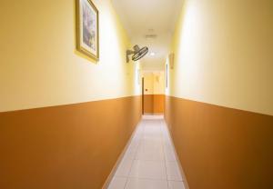 a hallway with yellow walls and a tile floor at Sun Inns Hotel Sunway Mentari in Petaling Jaya