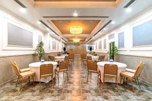 a restaurant with tables and chairs in a room at ESPERO INN Malappuram in Malappuram