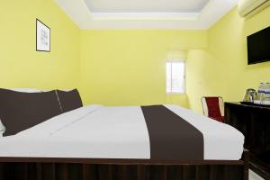 una camera da letto con un letto bianco e una televisione di Hotel O Grand Occasion a Rānchī