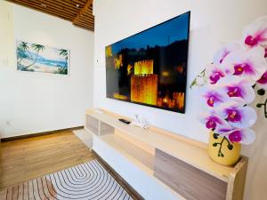 a living room with a tv and a vase with flowers at Villa Đại Dương View Biển Đảo Phú Quý in Cu Lao Thu