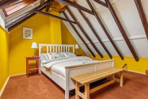 Un dormitorio con paredes amarillas y una cama y una mesa. en Winsum - Groningen - 6 pers. Cosy Cottage - Op en Bie t Woater, en Winsum