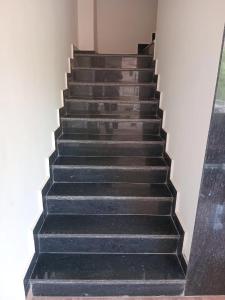 a stairway with black steps and a white wall at Hotel Garden View - Mansarovar in Jaipur