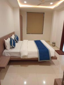 a bedroom with a large bed with blue and white pillows at Hotel Garden View - Mansarovar in Jaipur