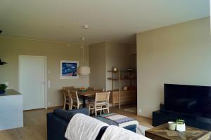 斯格茹德Modern Spacious Apt in Ski, 11min to Oslo的客厅里有一张蓝色的沙发和一张桌子