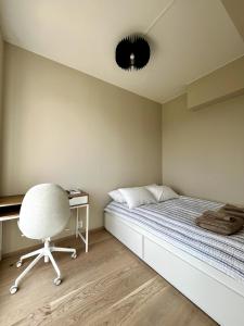 斯格茹德Modern Spacious Apt in Ski, 11min to Oslo的一间卧室，配有一张床、一把椅子和一张书桌
