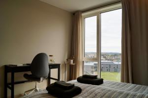 斯格茹德Modern Spacious Apt in Ski, 11min to Oslo的一间卧室，里面有一张床、一把椅子和一扇窗户