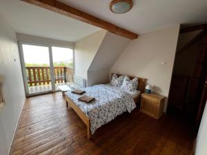 a bedroom with a bed and a balcony at Leonardo Guesthouse in Świeradów-Zdrój