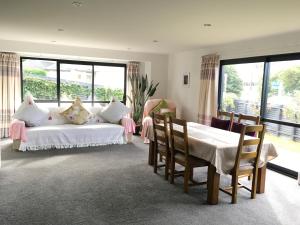 una camera da letto con un letto bianco, un tavolo e delle sedie di Central located new build 3 bed rooms entire house a Oamaru