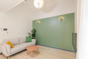 - un salon avec un canapé et un mur vert dans l'établissement Jeju Aewol Sugar Pension, à Jeju