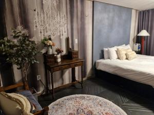 a bedroom with a bed and a table with a chair at Gangneung Jeongdongjin Gianni Pension in Gangneung
