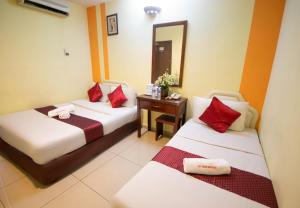 a hotel room with two beds and a mirror at Sun Inns Hotel Sunway Mentari in Petaling Jaya +27 photos