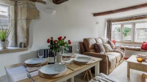 a living room with a table and a couch at Loveview - A Painswick Stone Haven in Painswick