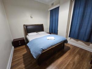 a bedroom with a bed with blue sheets and a window at Court House Hotel in Lithgow