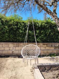 a basket swing hanging from a tree at La Casetta di Camelia in Fontane Bianche