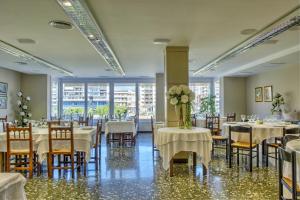 uma sala de jantar com mesas, cadeiras e janelas em Hotel Balaguer em Balaguer