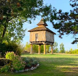a bird house sitting in the middle of a field at Moulin de Bordes in Loze