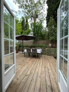 an open porch with a table and an umbrella at Mobil-home 4 Couchages Parking gratuit in Villeneuve-Loubet