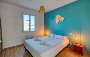 Un dormitorio con una cama grande con una pared azul. en Stunning Home In La Brée-Les-Bains, en La Brée-les-Bains 24 fotos más
