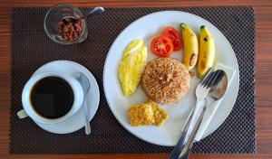 a plate of breakfast food and a cup of coffee at Guest House d Valeri in Labuan Bajo