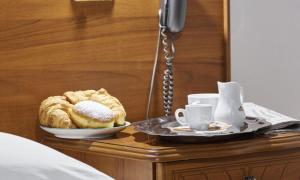 un tavolo con un piatto di prodotti da forno e una tazza di caffè di Casa Hellen a Monteforte dʼAlpone