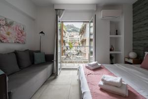 a bedroom with a bed and a couch and a window at Trikoupi 95 in Athens