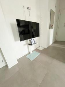 a white room with a flat screen tv on a wall at Suite Tra il Centro e il Mare,Vicino Stazione in Savona