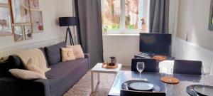 a living room with a couch and a table at Côté Jardin la belle époque in La Bourboule