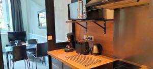 una camera con tavolo e macchinetta del caffè. di Côté Jardin la belle époque a La Bourboule