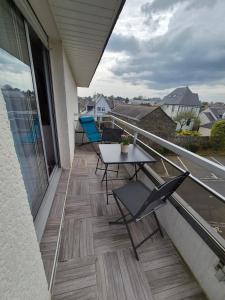 a balcony with a table and chairs on a balcony at L'ancre du Port in Saint-Quay-Portrieux